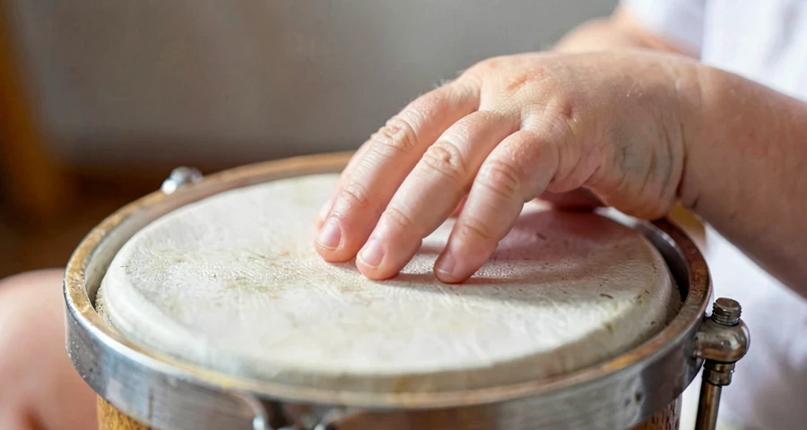 mão de bebê batendo em tambor durante atividade musical na creche