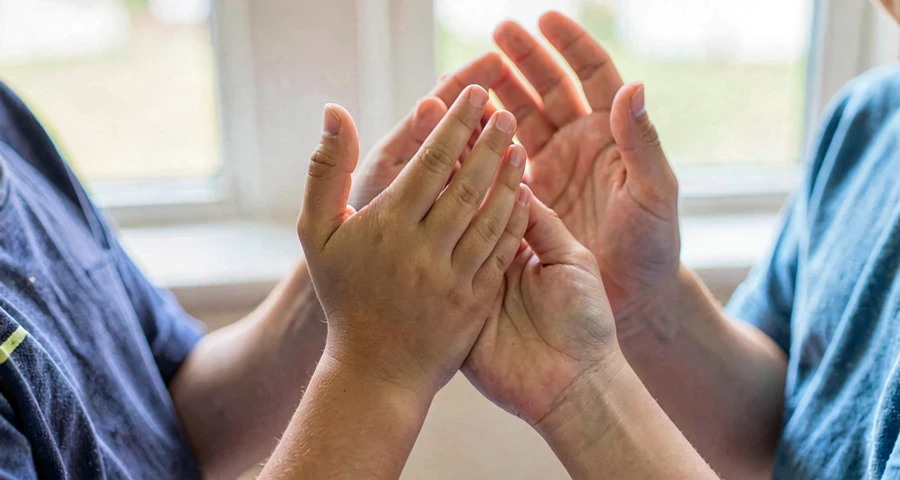 mãos de crianças batendo palmas juntas em brincadeira tradicional
