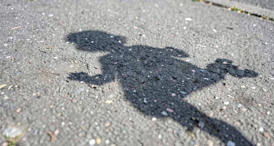 sombra de criança contornada com giz no chão em atividade investigativa