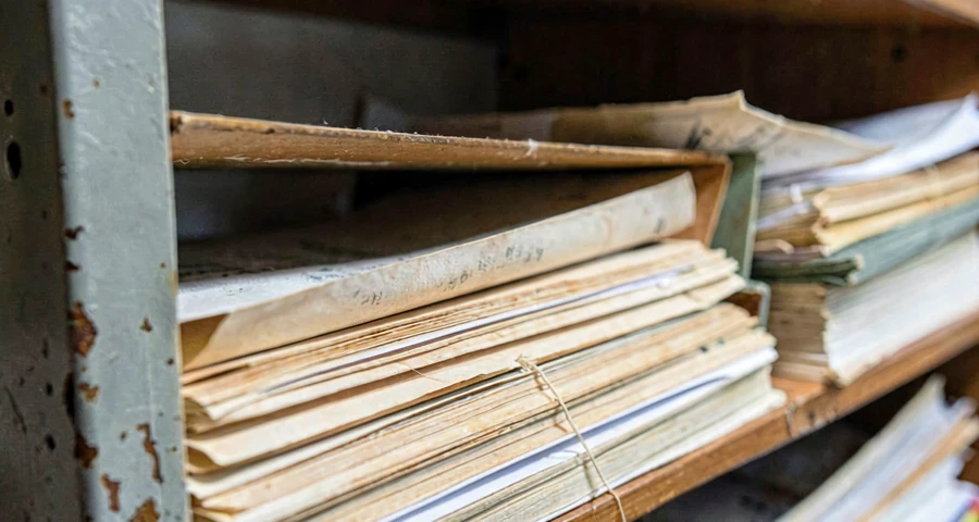 arquivo histórico físico com documentos antigos em pastas de papel