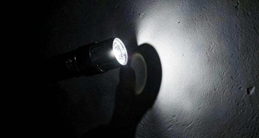 lanterna projetando sombra nítida de objeto opaco em experimento sobre propagação da luz