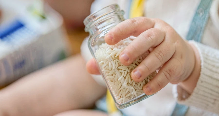bebê balançando garrafinha com arroz durante atividade sonora na creche
