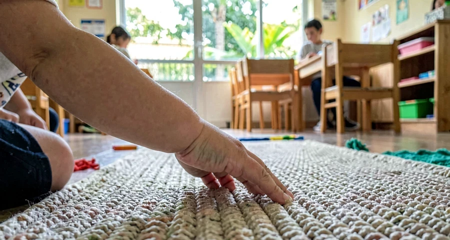 mão de bebê tocando tapete de textura durante percurso sensorial na creche
