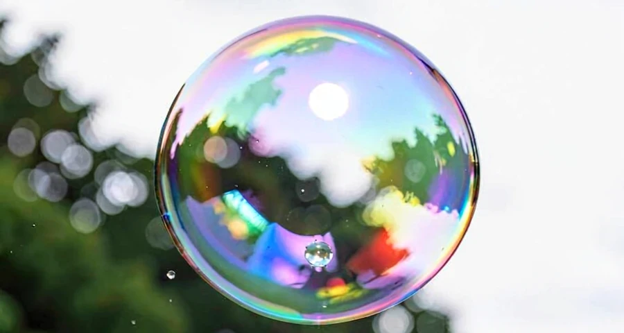 bolha de sabão gigante flutuando no ar com reflexos coloridos