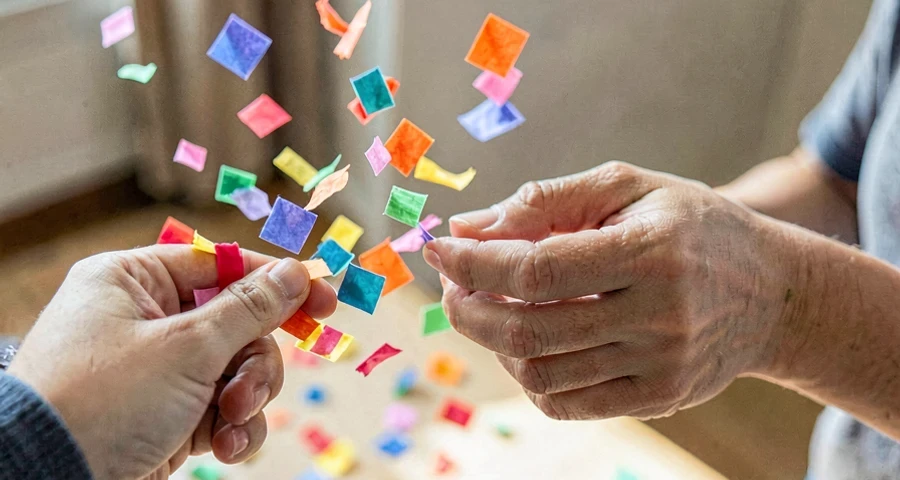 criança da creche jogando confete colorido em atividade investigativa na creche