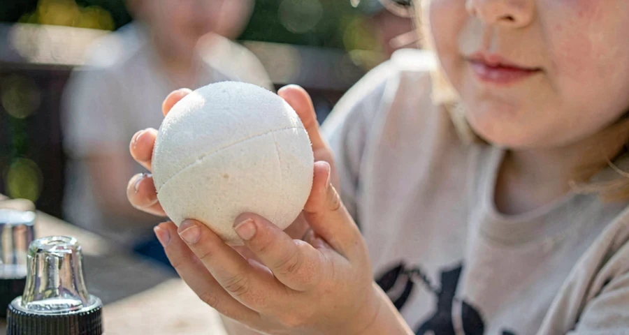 criança lançando bola em direção aos pinos durante jogo de boliche