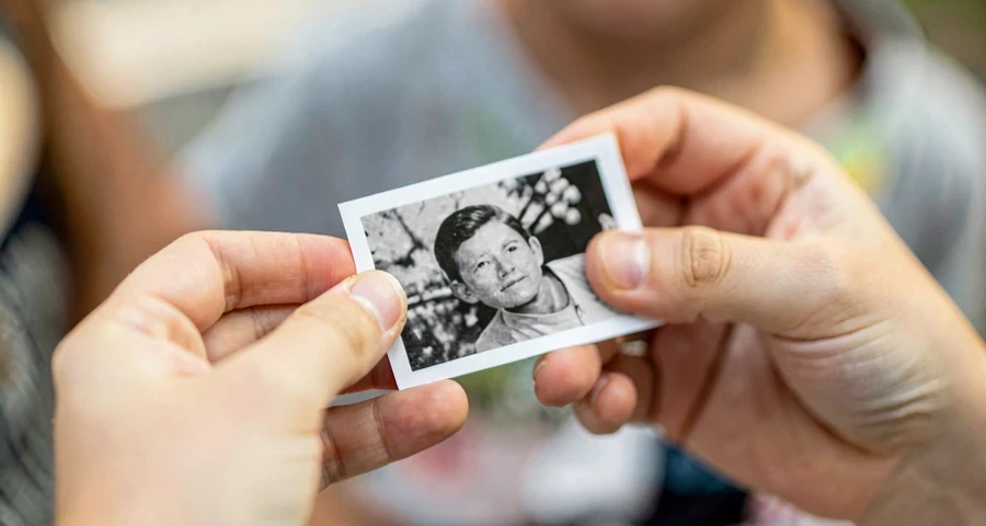 mãos de criança segurando fotografia impressa durante atividade de narrativa oral