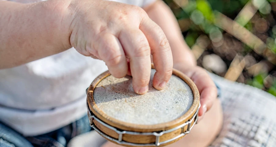 bebê tocando pandeiro durante atividade sonora na creche