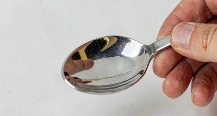 colher metálica refletindo imagem distorcida em atividade investigativa na creche